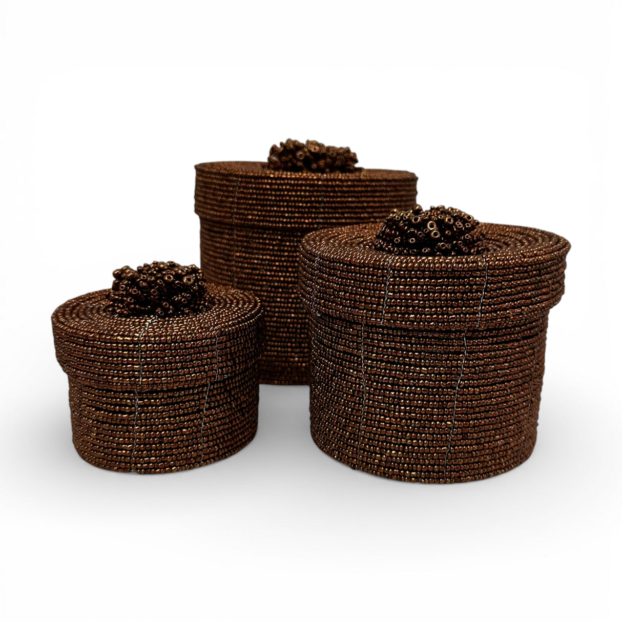 Set of three handcrafted cylindrical storage baskets with rich chocolate brown wooden beads, matching fitted lids, and decorative beaded handles, perfect for stylish storage and adding warmth to living rooms, bedrooms, or bathrooms.