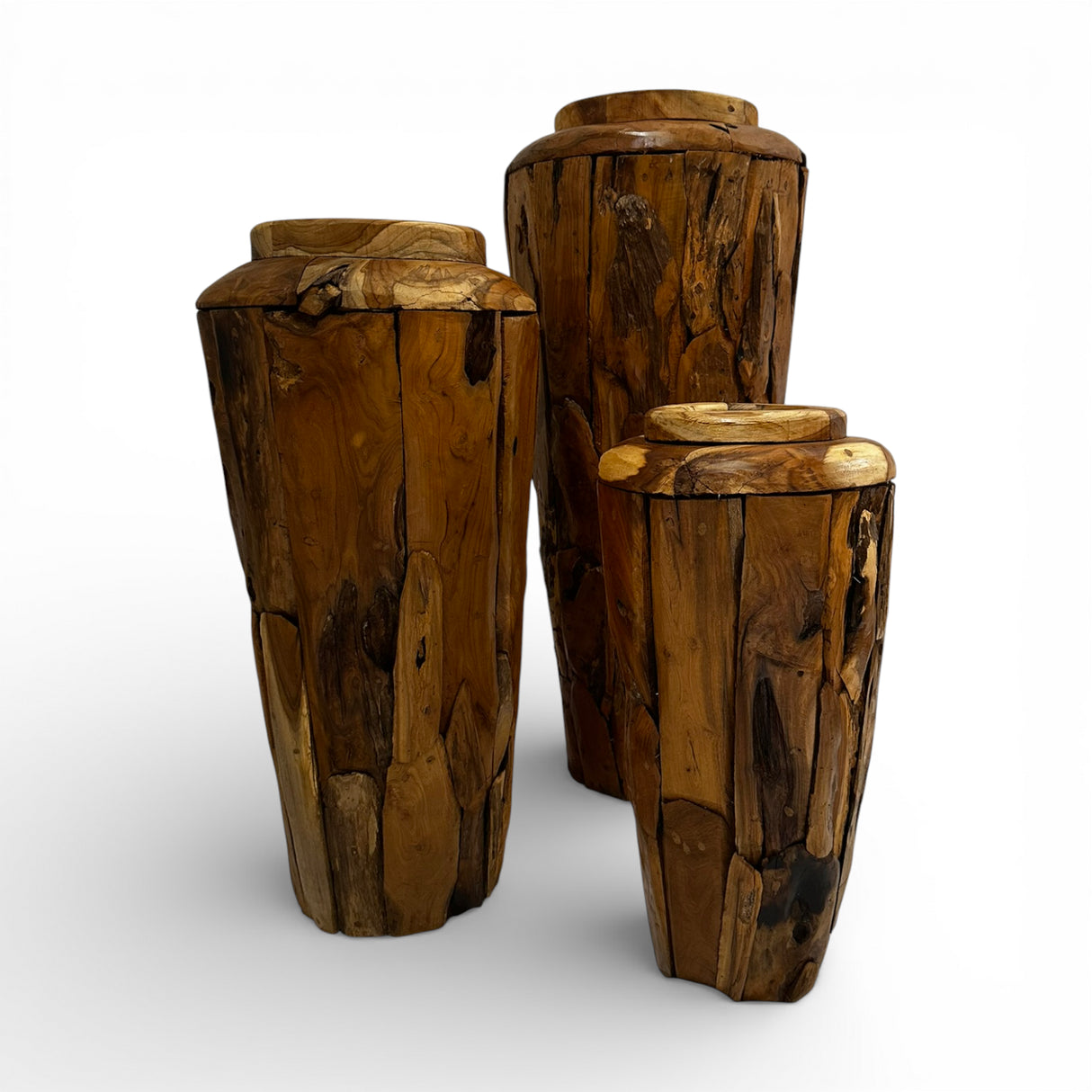 Set of three handcrafted teak wood decorative vases in assorted sizes, featuring rich natural wood grain, organic textures, and a sculptural cylindrical design. Perfect as statement décor for modern, rustic, or contemporary interiors.