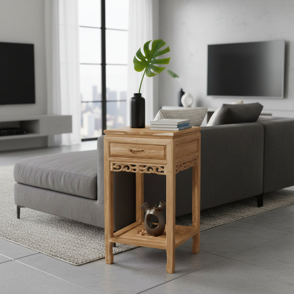 Wooden side table in a modern living room with gray sofa and large windows.