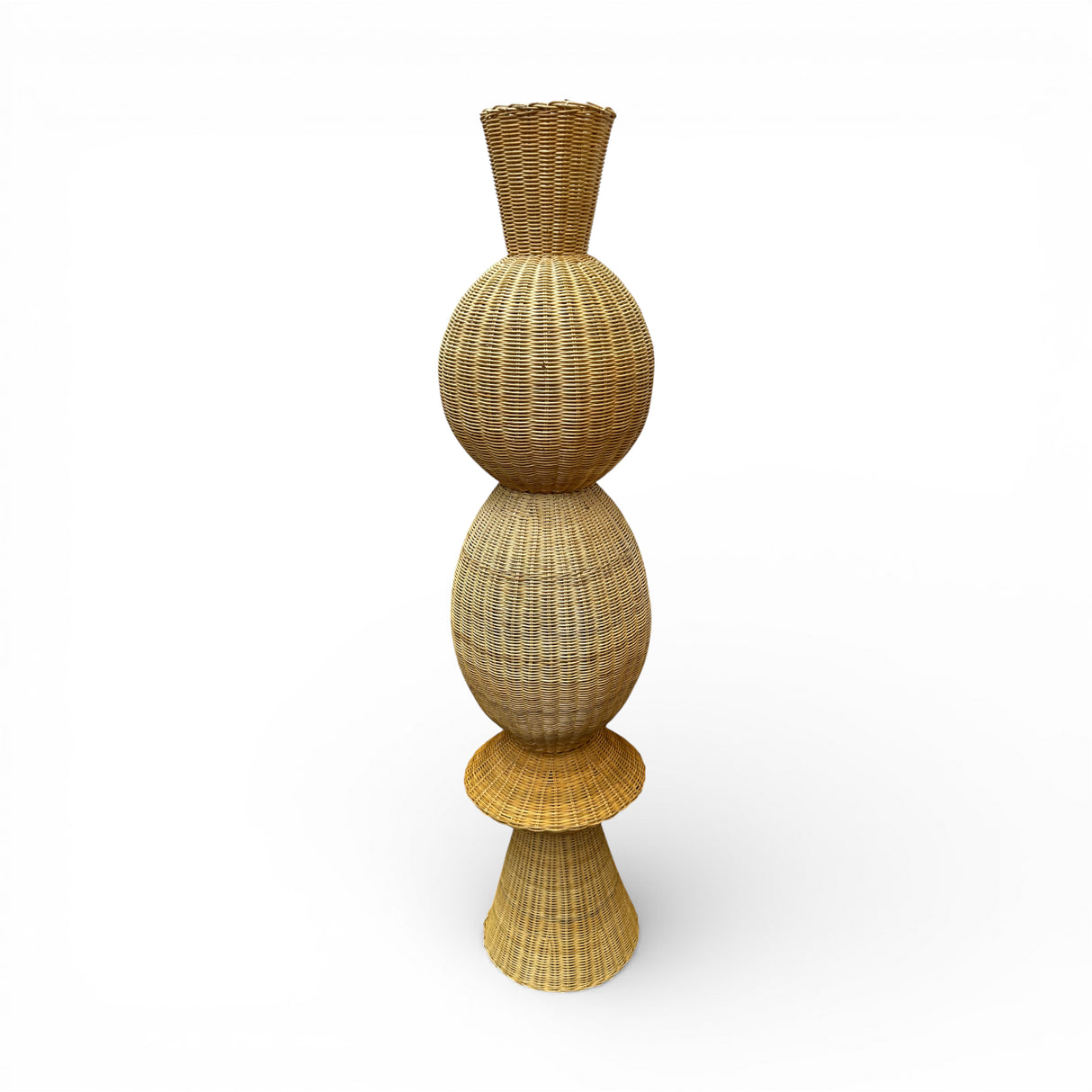 Tall handwoven sculptural floor vase featuring a natural wicker finish with a stacked organic silhouette and flared base. A striking decorative statement piece that adds warmth, texture, and artisan charm to living rooms, entryways, boutique hotels, and contemporary interiors.