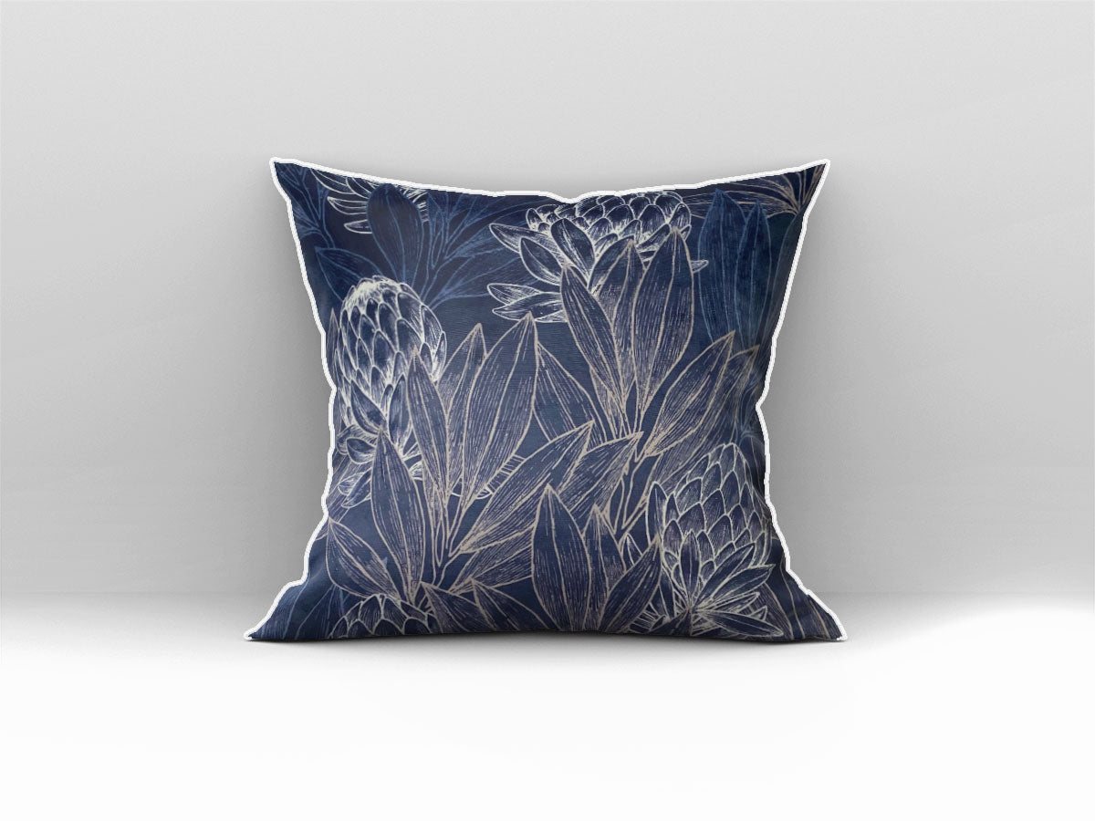 Decorative navy blue scatter cushion featuring elegant protea flowers and botanical linework in soft silver tones, finished with contrasting light piping.