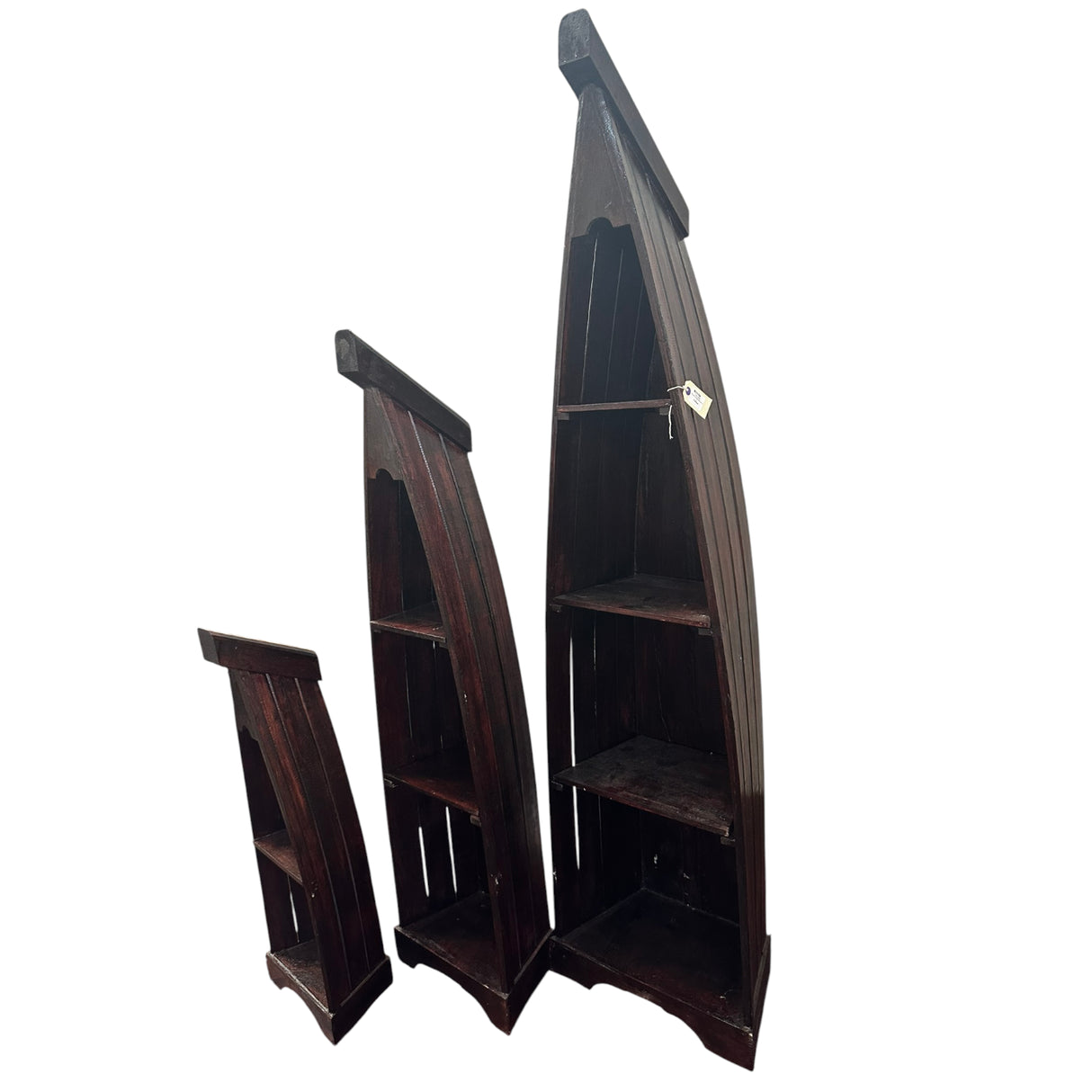 Set of three handcrafted canoe-shaped display shelves in dark stained solid wood, featuring open display compartments in three different sizes, shown together against a white background.