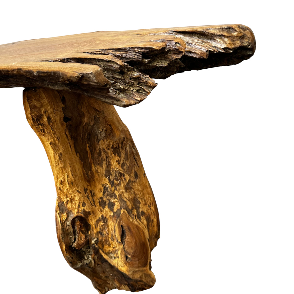 Close-up of a rustic live edge teak bench showcasing the natural wood grain, organic edge profile, and sculptural solid timber leg, highlighting handcrafted craftsmanship and natural beauty.