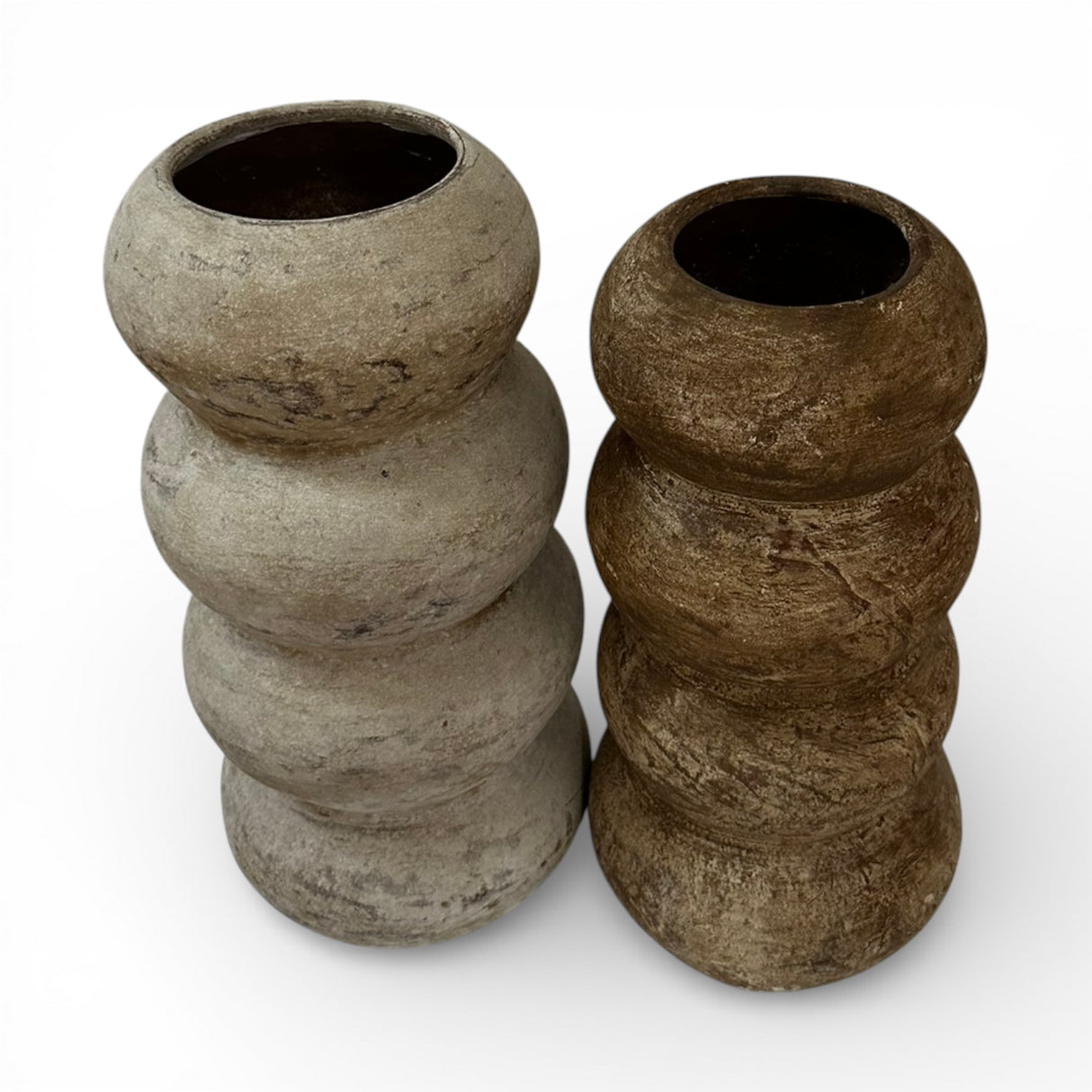 Set of two stacked sculptural decorative vases with rounded segmented silhouettes in natural stone and dark brown finishes. Featuring organic textures and wide openings, these contemporary statement vases add warmth and modern elegance to shelves, console tables, or coffee table displays.