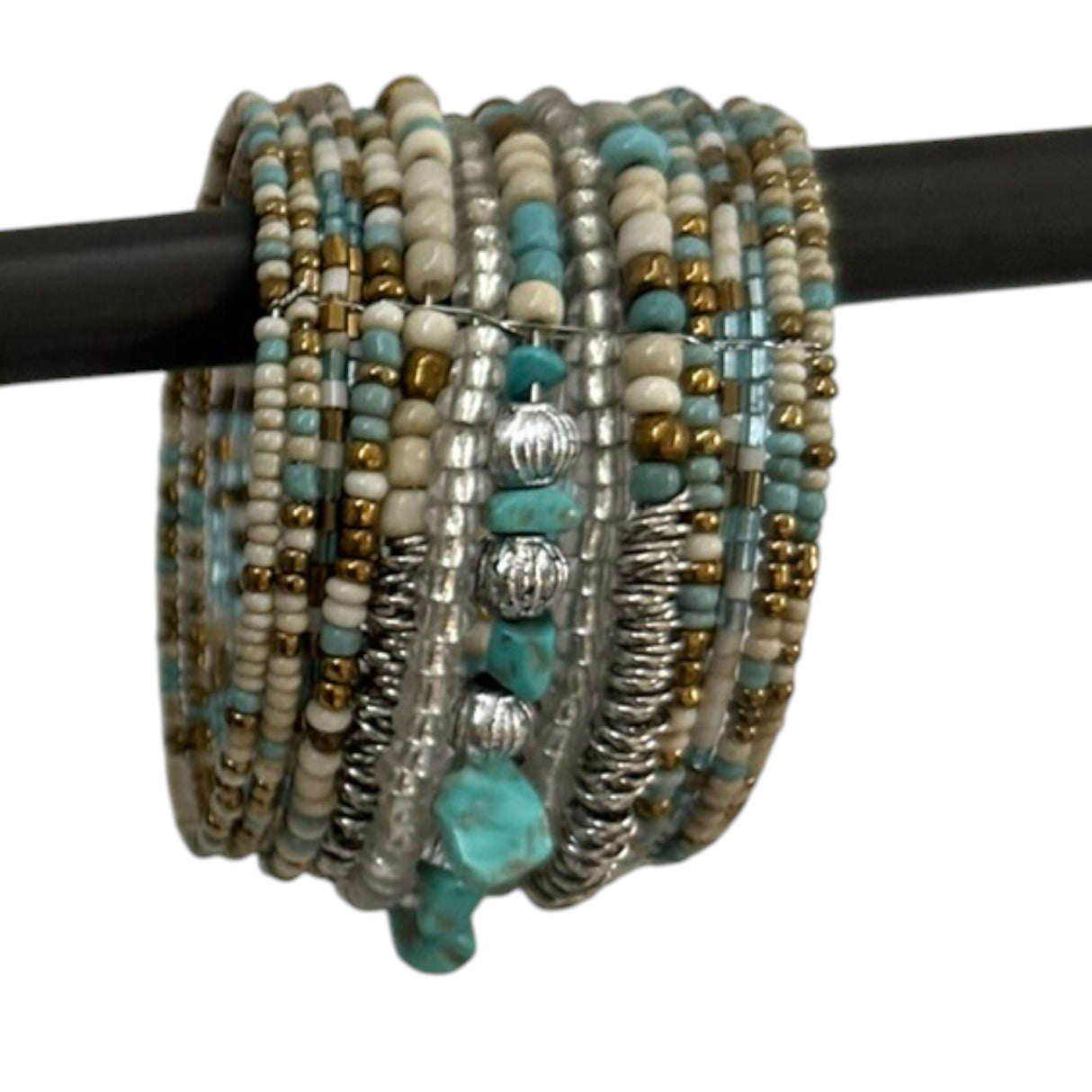 Handcrafted multi-layer wrap bracelet featuring turquoise, ivory, silver, and gold-toned seed beads with natural turquoise stone accents, displayed wrapped around a black jewelry display rod.