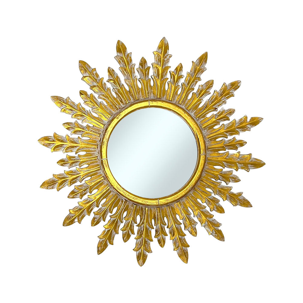Decorative round wall mirror with an antique gold laurel-inspired sunburst frame featuring elegant branching leaf rays and a distressed metallic finish, creating a timeless luxury statement for any interior.