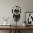 Handcrafted black beaded tribal sculpture mounted on a metal stand, featuring layered circular beadwork and dramatic fringe detailing. A contemporary African-inspired decorative accent for consoles, shelves, and tabletops in modern, minimalist, or luxury interiors.