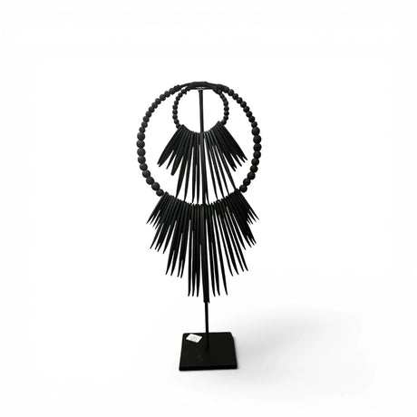 Handcrafted black beaded tribal sculpture mounted on a metal stand, featuring layered circular beadwork and dramatic fringe detailing. A contemporary African-inspired decorative accent for consoles, shelves, and tabletops in modern, minimalist, or luxury interiors.