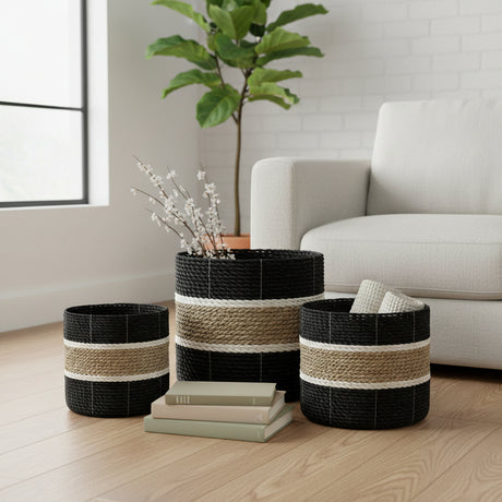 Set of woven baskets on a wooden floor with a plant and books in a living room setting.