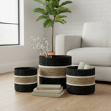 Set of three woven storage baskets featuring bold black, natural beige and cream horizontal stripes in varying sizes, styled in a modern living room.