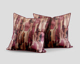Set of three decorative scatter cushions featuring a watercolour-inspired abstract pattern in blush pink, burgundy, rust, brown, and soft neutral tones with coordinating piping.