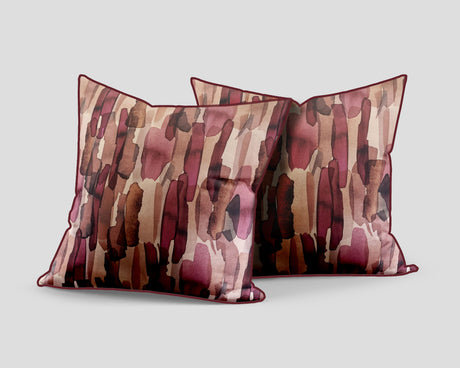 Set of three decorative scatter cushions featuring a watercolour-inspired abstract pattern in blush pink, burgundy, rust, brown, and soft neutral tones with coordinating piping.