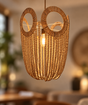 A bohemian-style pendant light made of woven natural rattan and hanging wooden beads, suspended in a warm, softly blurred interior setting.