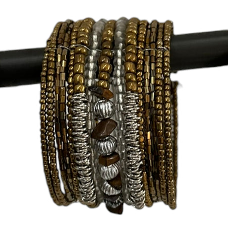 Handcrafted multi-layer wrap bracelet featuring bronze, silver, and clear seed beads with natural brown stone accents and textured metallic spacer beads, displayed wrapped around a black jewelry display rod.