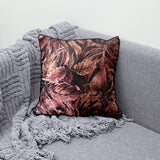 Decorative scatter cushion featuring a rich burgundy and dusty rose botanical leaf pattern with dark piping, perfect for adding warmth and sophisticated pattern to stylish interiors.