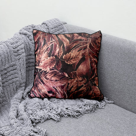 Decorative scatter cushion featuring a rich burgundy and dusty rose botanical leaf pattern with dark piping, perfect for adding warmth and sophisticated pattern to stylish interiors.