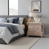 Elegant natural wood bedside table featuring two drawers, intricate carved detailing, decorative corner columns, and turned wooden feet.