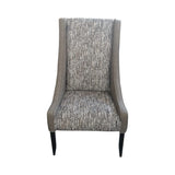 Modern high-back dining chair upholstered in textured grey fabric with contrasting patterned seat and backrest panels. Featuring gently curved wingback sides and sleek dark wooden legs, this elegant chair is ideal for dining rooms, restaurants, boutique hotels, or contemporary interiors.