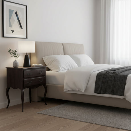 Neatly made bed in a bedroom with a side table and lamp.