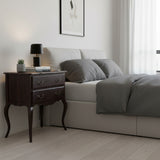Modern bedroom with a bed and nightstand featuring a lamp and books.