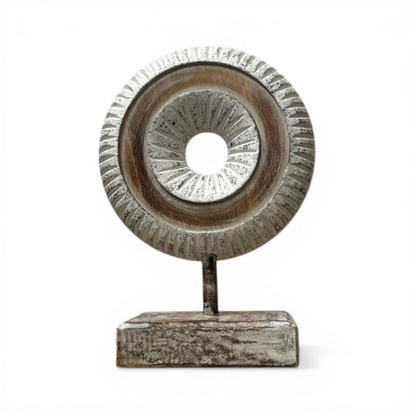 Decorative carved wooden ring sculpture mounted on a sturdy stand, featuring intricate radial detailing in distressed natural wood tones. A contemporary tabletop accent that adds texture and elegance to modern, Scandinavian, rustic, and minimalist home décor.