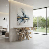 Handcrafted driftwood root console table featuring a sculptural natural wood root base with a rectangular tabletop, styled beneath modern wall art in a contemporary living space.