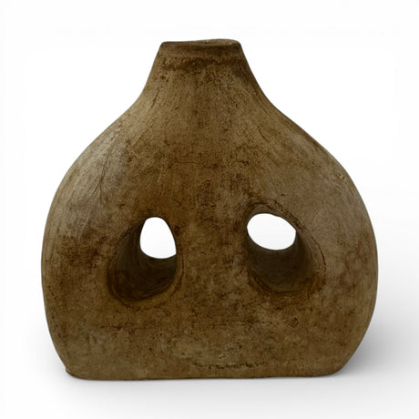 Handcrafted sculptural stoneware vase with a warm earthy finish, featuring a rounded organic silhouette, two asymmetrical cut-out openings, and a narrow neck. A contemporary decorative statement piece that adds texture, artistic character, and modern elegance to shelves, console tables, coffee tables, or styled interiors.