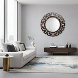 Round espresso-finish geometric wall mirror with a bold Greek key-inspired frame, styled above a modern console table with decorative accessories in a contemporary interior.