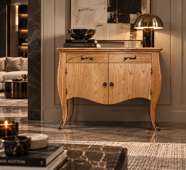 A light natural wood French console cabinet with curved legs, two drawers, and two doors with dark metal knobs, styled in a luxury living room setting.