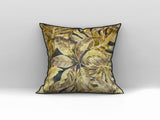 Decorative scatter cushion featuring a rich tropical leaf pattern in gold, mustard, olive, and deep charcoal tones with contrasting dark piping.
