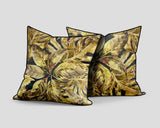 Set of three decorative scatter cushions featuring a rich tropical leaf pattern in gold, mustard, olive, and charcoal tones with contrasting dark piping.