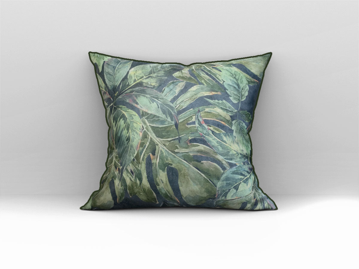 Decorative scatter cushion featuring a lush tropical leaf pattern in layered green, sage, and deep blue tones with coordinating dark green piping.