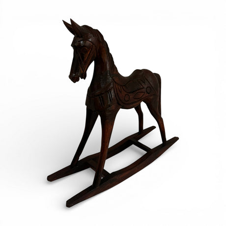 Hand-carved dark wood rocking horse sculpture featuring intricate artisan detailing and a rich polished finish, perfect as a timeless decorative accent for consoles, shelves, coffee tables, or classic and contemporary interiors.