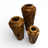 Set of three handcrafted live edge wooden planter pedestals made from solid natural timber, featuring rich organic wood grain, sculptural tapered forms, and varying heights, perfect for displaying indoor plants or creating a striking decorative feature.