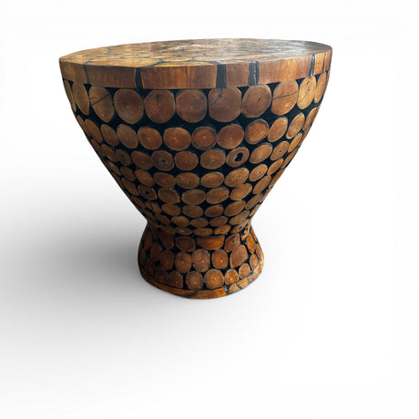 Handcrafted pedestal table made from natural wood log slices, featuring a sculptural hourglass silhouette and a polished wooden top that highlights the unique grain and texture of each piece. Ideal as a side table, accent table, or statement décor piece for homes, lodges, cafés, or rustic-inspired interiors.
