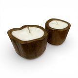 Set of handcrafted candles poured into solid teak wood vessels with organic freeform rims, showcasing the natural grain and warm timber tones of the wood. These rustic-modern candles make elegant decorative accents for coffee tables, dining tables, shelves, boutique hotels, or contemporary interiors.