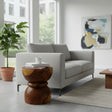 Handcrafted sculptural side table crafted from solid teak wood, featuring a smooth rounded tabletop and an elegant hourglass pedestal base that highlights the rich natural wood grain. A timeless statement piece perfect for living rooms, bedrooms, boutique hotels, lodges, or contemporary luxury interiors.