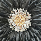 Decorative item with black feathers and a central beige flower-like design