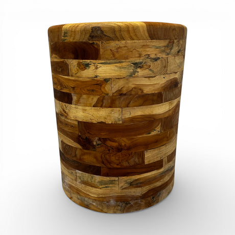 Handcrafted drum-shaped side table crafted from solid teak wood, featuring a smooth cylindrical silhouette that showcases the rich natural grain and warm timber tones in a distinctive patchwork design. Perfect as an accent table, bedside table, or decorative piece for living rooms, bedrooms, boutique hotels, lodges, or contemporary rustic interiors.