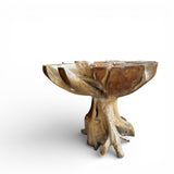 Handcrafted pedestal table carved from solid natural teak root, featuring an organic freeform top and sculptural root base that highlights the unique wood grain and natural character of each piece. An eye-catching statement table for living rooms, lodges, luxury homes, or nature-inspired interiors.