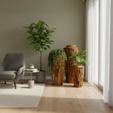 Set of handcrafted teak wood floor vases in varying heights, styled with lush greenery in a modern living space. Featuring rich natural wood grain and organic textures, these statement vases bring warmth and character to contemporary interiors.