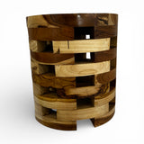 Handcrafted cylindrical accent table crafted from solid teak wood, featuring a unique open-block design with integrated storage compartments that showcase the natural grain and warm timber tones. A functional statement piece perfect as a side table, bedside table, or decorative accent for living rooms, bedrooms, boutique hotels, lodges, or contemporary rustic interiors.