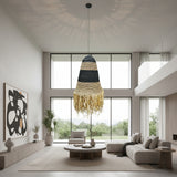 Handwoven pendant light featuring black and natural woven bands with a tapered silhouette and decorative fringe, creating warm ambient lighting and a relaxed bohemian statement for dining rooms, bedrooms, living spaces, or covered patios.