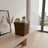 Handwoven dark rattan storage basket with a rich espresso finish and sturdy wooden rim, styled with a rolled towel, books, and a potted succulent, perfect for stylish storage in bathrooms, living rooms, or bedrooms.