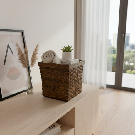 Handwoven dark rattan storage basket with a rich espresso finish and sturdy wooden rim, styled with a rolled towel, books, and a potted succulent, perfect for stylish storage in bathrooms, living rooms, or bedrooms.