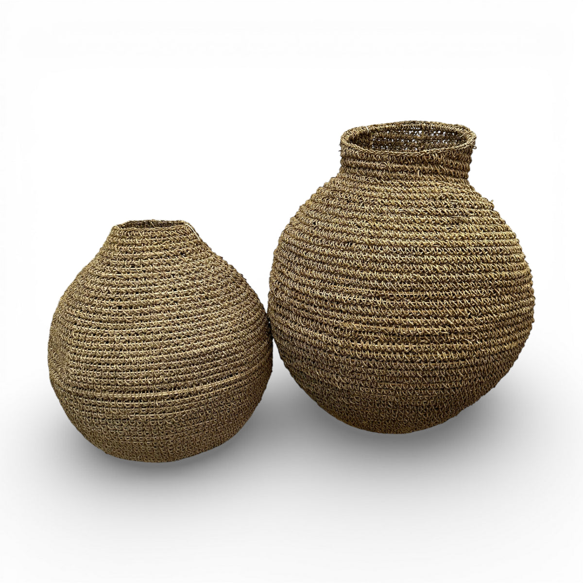 Set of two handwoven natural decorative vases with sculptural rounded silhouettes and textured woven finishes, perfect for displaying dried botanicals or adding warm organic texture to contemporary, coastal, or rustic interiors.