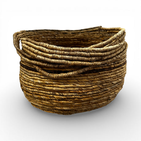 Handwoven natural storage basket with integrated carry handles and a soft organic silhouette, perfect for storing blankets, cushions, toys, or everyday essentials while adding warm texture and artisanal style to contemporary, coastal, or rustic interiors.