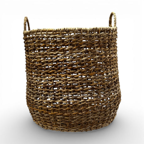 Handwoven natural storage basket with an open-weave design, integrated carry handles, and a soft organic silhouette, perfect for storing blankets, cushions, toys, or everyday essentials while adding warm texture and timeless artisanal style to contemporary, coastal, and rustic interiors.