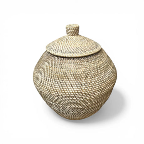 Handwoven natural storage basket with a matching fitted lid, rounded silhouette, and light neutral finish. Perfect for storing household essentials while adding texture and style to coastal, Scandinavian, boho, modern, or rustic home interiors.