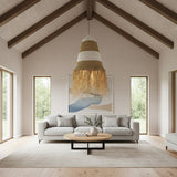 Handwoven pendant light featuring natural, olive, and white woven stripes with a tapered silhouette and decorative raffia fringe, beautifully styled above a contemporary living room to add warm ambient lighting, organic texture, and relaxed bohemian elegance.